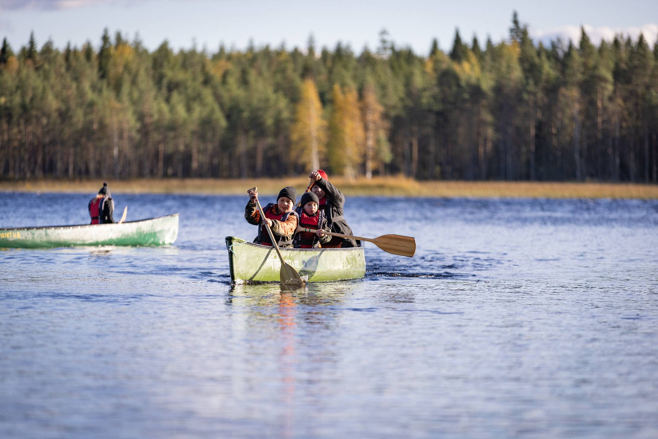 Perhe meloo Metsäkartanon kanootilla ruskan keskellä